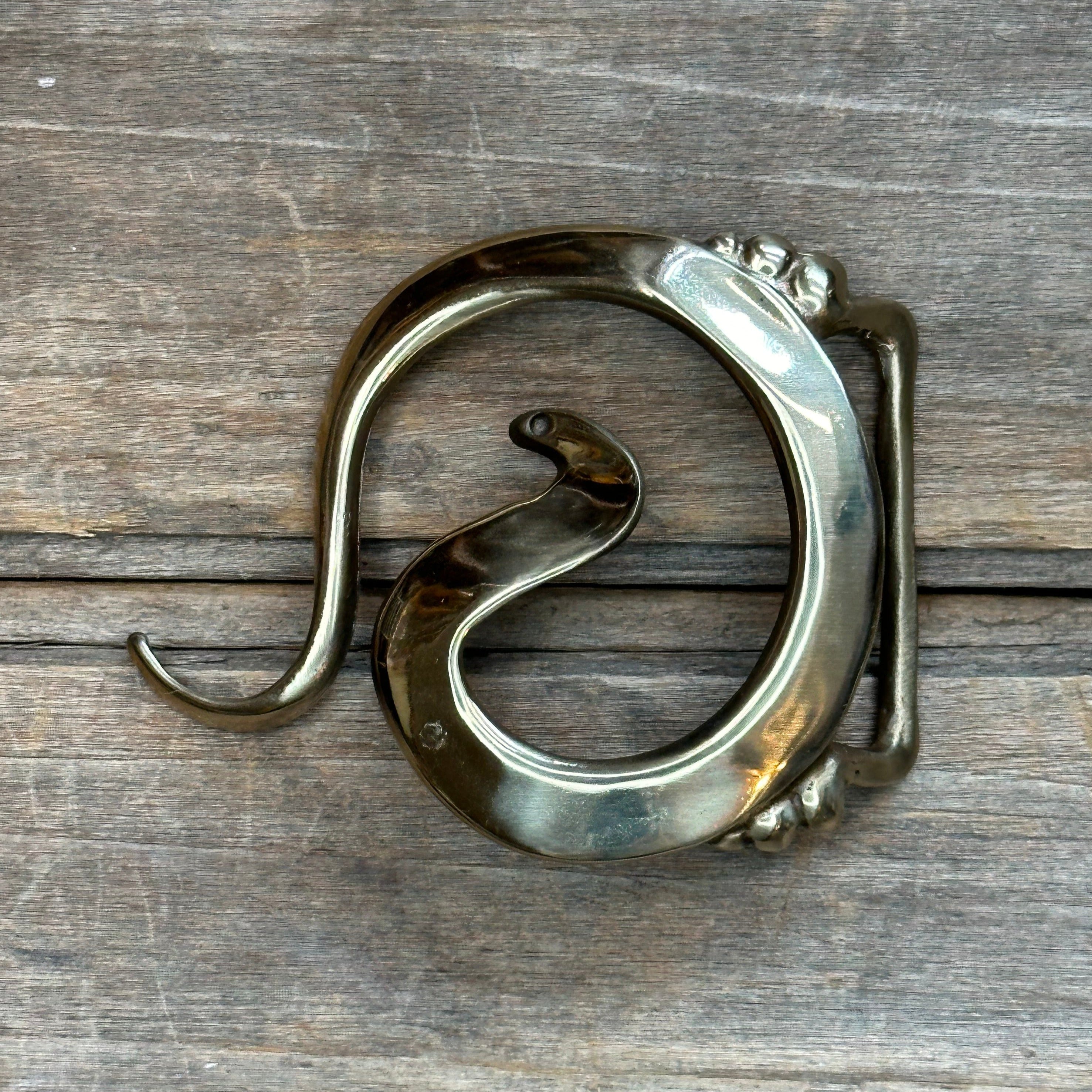 This is a brass buckle with a golden tone.
