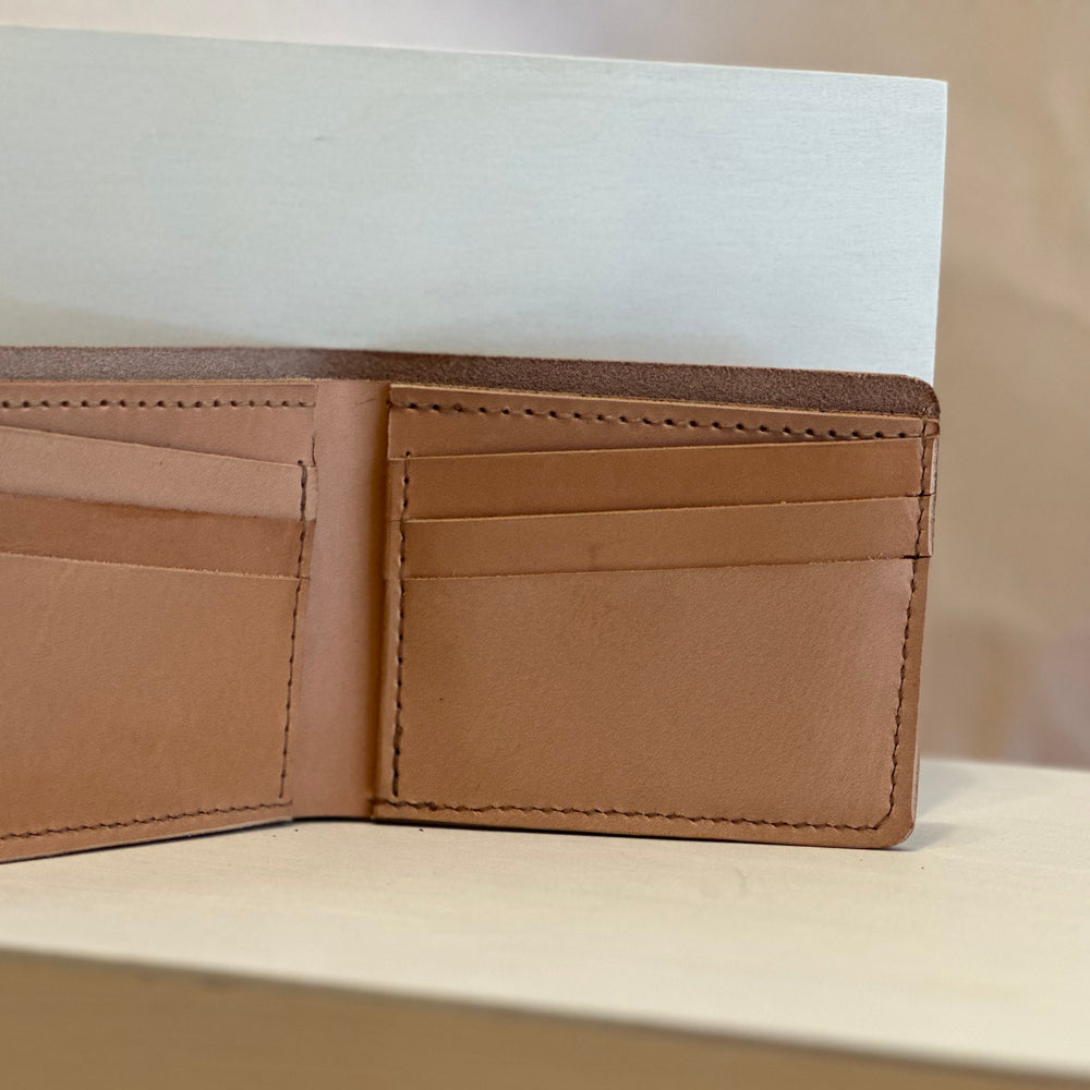 Our Veg Tan Bi Fold Leather Wallet is handmade and hand stitched from high quality top grain solid leather.  It is a workhorse and makes a stylish statement from farm to table.  Perfect for your everyday carry and designed to last the test of time.