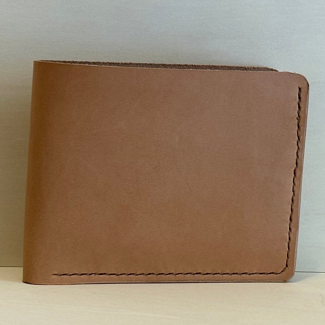 Our Veg Tan Bi Fold Leather Wallet is handmade and hand stitched from high quality top grain solid leather.  It is a workhorse and makes a stylish statement from farm to table.  Perfect for your everyday carry and designed to last the test of time.