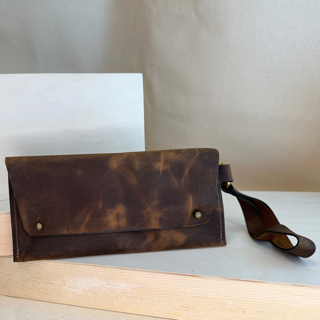 Our Brown Pull Up Handstitched Leather Clutch offers a classic, stylish look that's built to last. Crafted with solid, top grain leather, this clutch wallet is perfect for holding all your everyday essentials. Enjoy clean, simple design lines with this shop favorite.