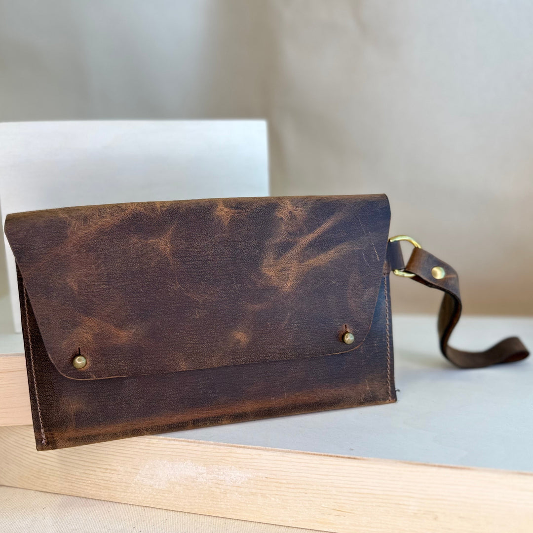 Our Brown Pull Up Handstitched Leather Clutch offers a classic, stylish look that's built to last. Crafted with solid, top grain leather, this clutch wallet is perfect for holding all your everyday essentials. Enjoy clean, simple design lines with this shop favorite.