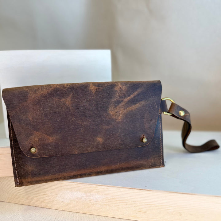Our Brown Pull Up Handstitched Leather Clutch offers a classic, stylish look that's built to last. Crafted with solid, top grain leather, this clutch wallet is perfect for holding all your everyday essentials. Enjoy clean, simple design lines with this shop favorite.