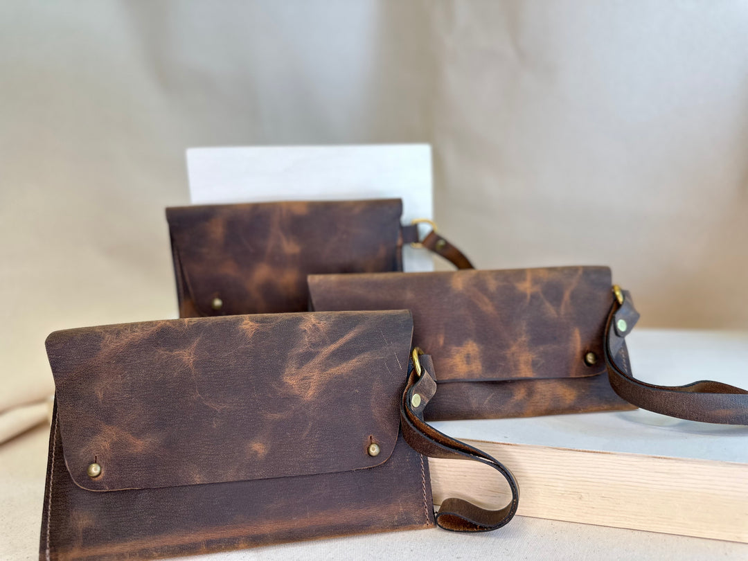 Our Brown Pull Up Handstitched Leather Clutch offers a classic, stylish look that's built to last. Crafted with solid, top grain leather, this clutch wallet is perfect for holding all your everyday essentials. Enjoy clean, simple design lines with this shop favorite.