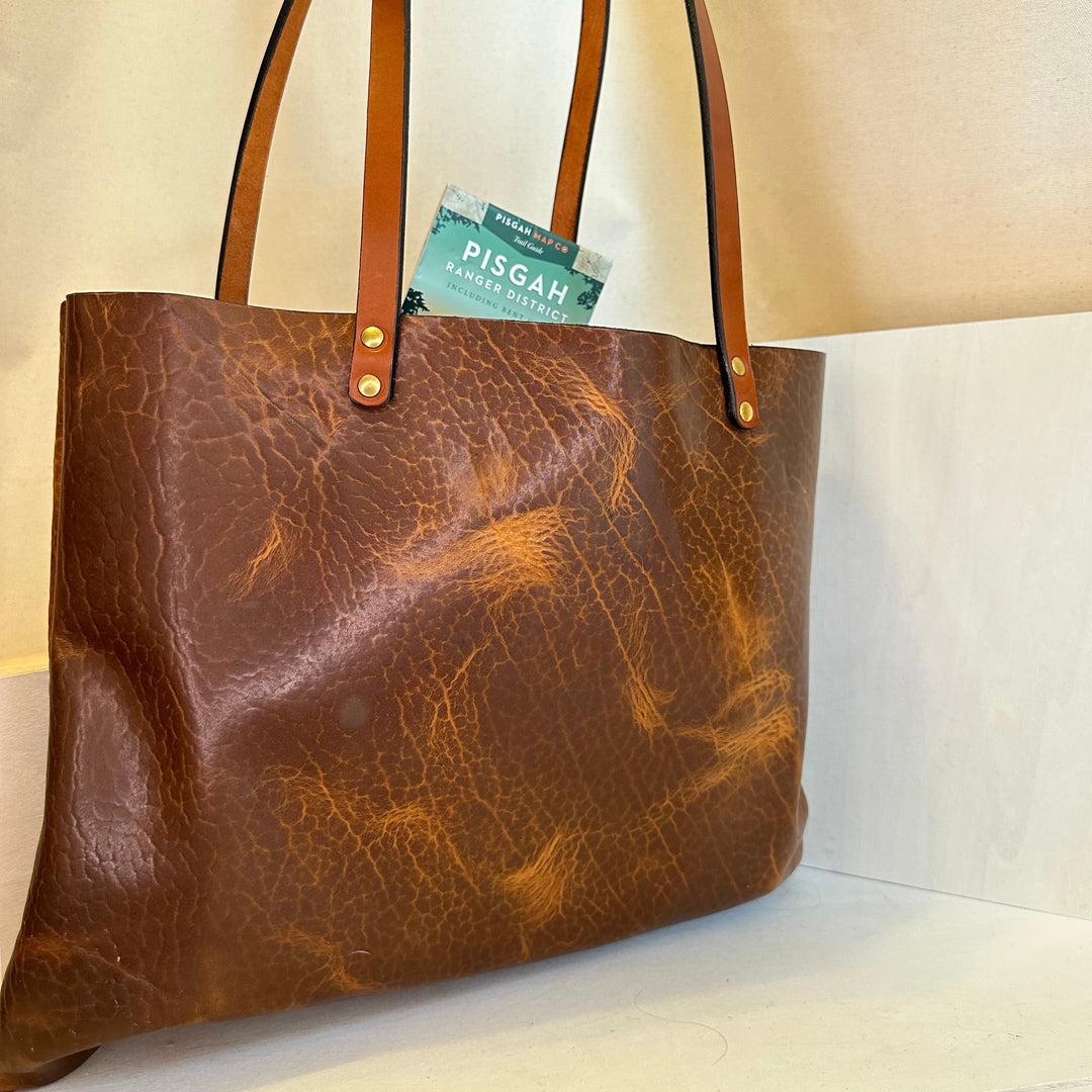 Shining Rock Goods crafts each and every bag in our Asheville, NC studio.  Our tote bags are made of USA tanned, solid, top grain, high quality, supple leather.  This bag will stand the test of time, more than normal wear and tear; it shows up and shows out.