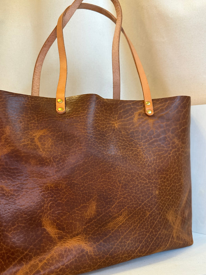 The Shining Rock Goods First Class LX Glazed Bison Leather Tote Bag is crafted from top grain, USA tanned leather, it is designed for maximum longevity and the quietest of luxury.