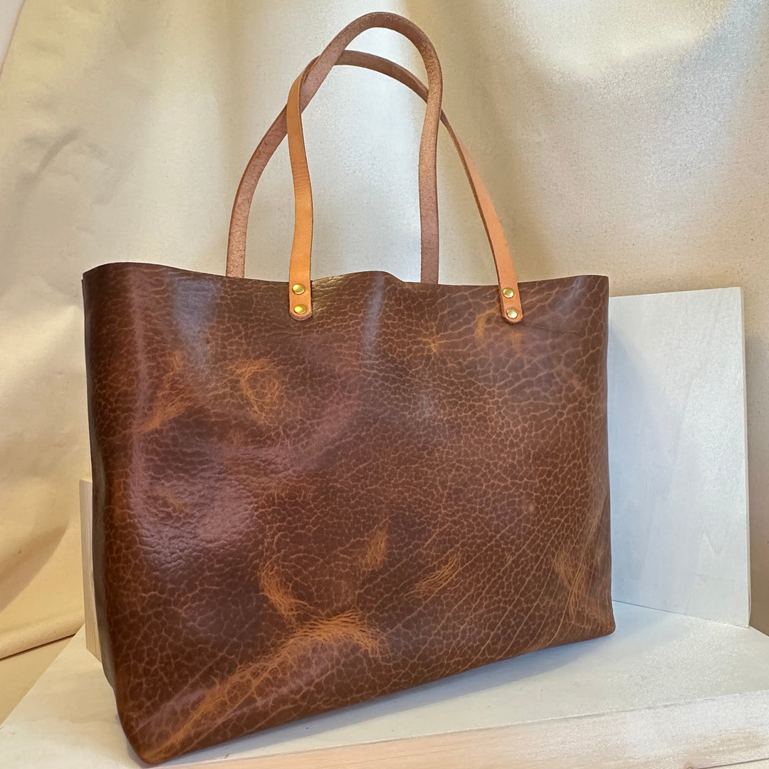 The Shining Rock Goods First Class LX Glazed Bison Leather Tote Bag is crafted from top grain, USA tanned leather, it is designed for maximum longevity and the quietest of luxury.