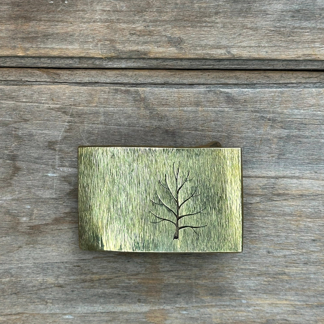 The "Tree" belt buckle by David M. Bowman is a timeless and durable design for those who wish to have a simple "go to" belt buckle to wear for any occasion.&nbsp; These belt buckles are handmade by David and his son Reed in their West Berkely, California studio.&nbsp; Each piece is handmade of solid brass  and textured with a grinder, providing a durable glinting effect.