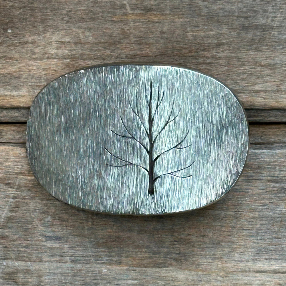 The "Tree" design by David M. Bowman is a timeless and durable design for those who wish to have a simple "go to" belt buckle to wear for any occasion.&nbsp; These belt buckles are handmade by David and his son Reed in their West Berkely, California studio. Each piece is handmade of solid nickel silver and textured with a grinder, providing a durable glinting effect.