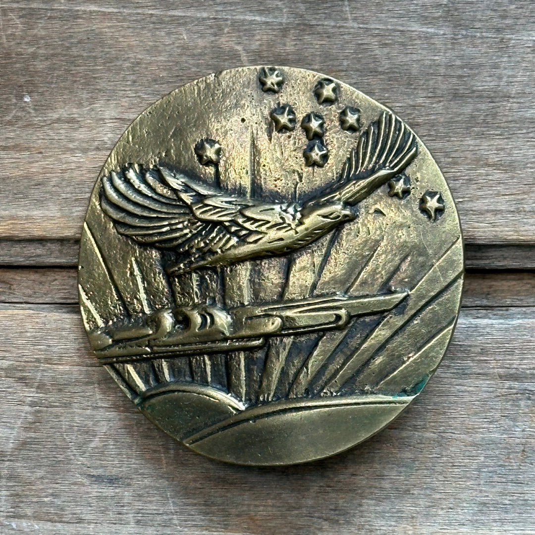 This is a solid brass belt buckle.  It depicts a hawk flying across the sky with a sunrise and stars in the background.