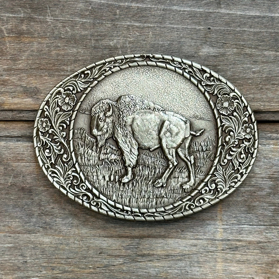 This is a solid brass belt buckle with a soft gold tone.  It depicts a Bison on a prairie and has a decorative border.