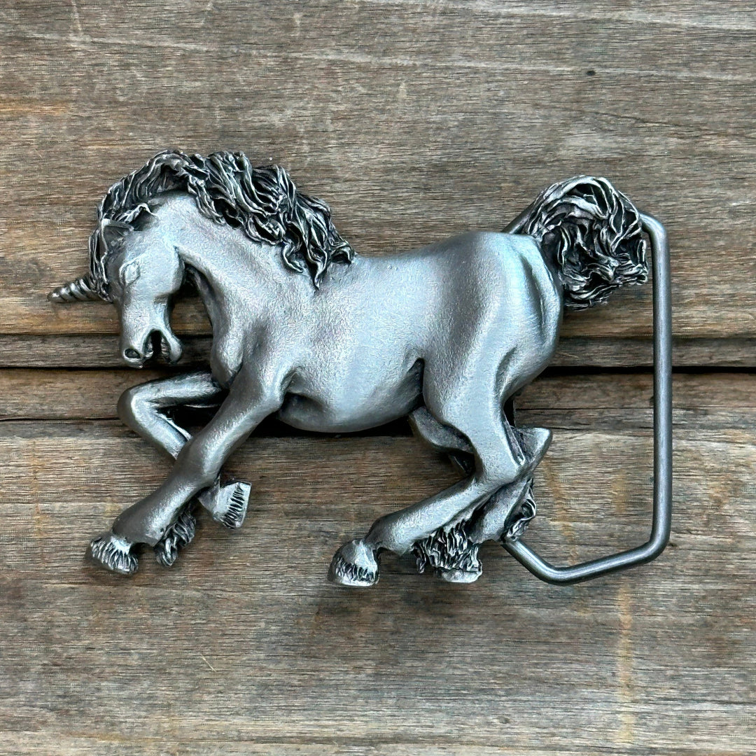 This is a pewter belt buckle with a silver tone.  It depicts a galloping unicorn.