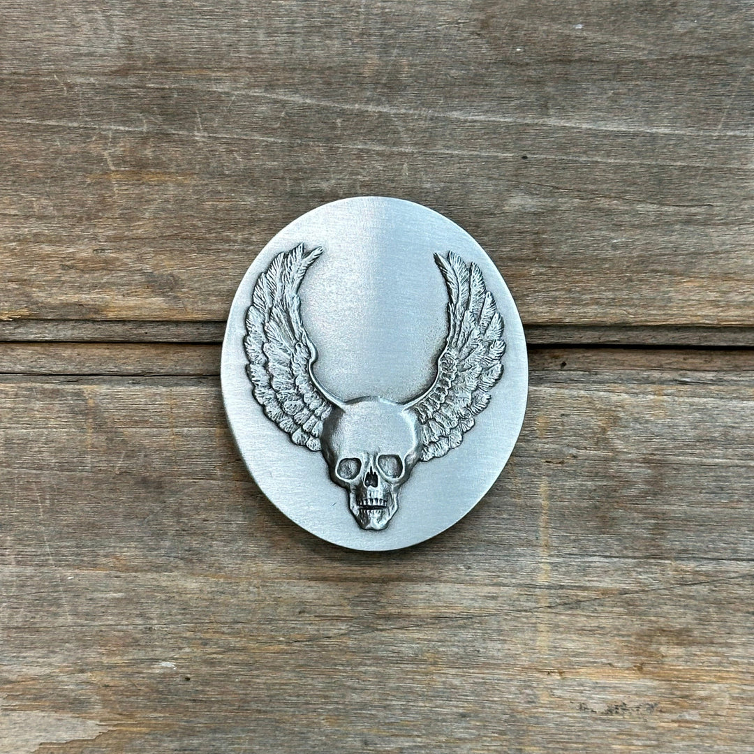 This is a pewter belt buckle with a silver tone.  It depicts a skull with wings.  It's pretty bad ass.