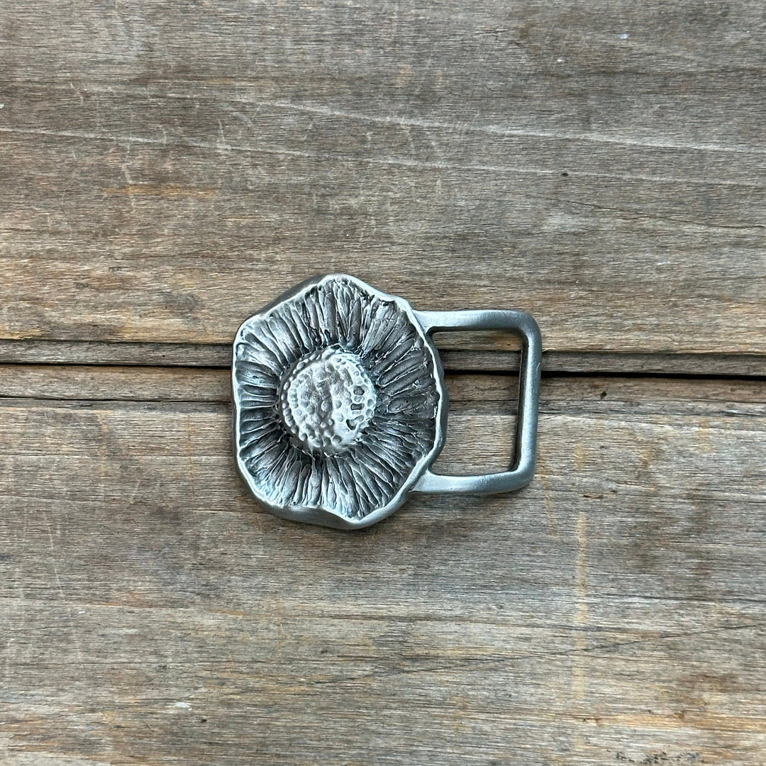 This is a pewter belt buckle with a sliver tone.  it is a mushroom from below with the texture of the gills and stem.